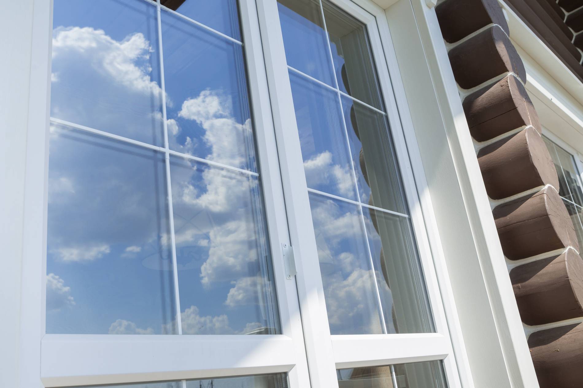 Plastic white window muntin bars with the reflection of the blue cloudy sky